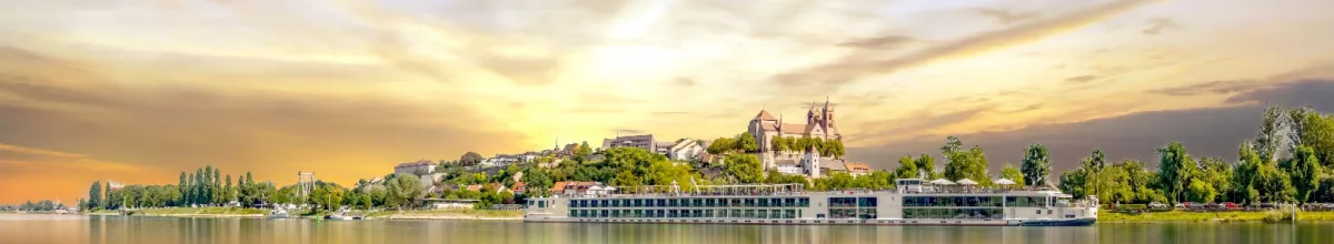 Ein Flusskreuzfahrtschiff bei Sonnenuntergang.