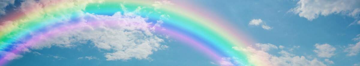 Ein Regenbogen erstrahlt am bewölkten Himmel.