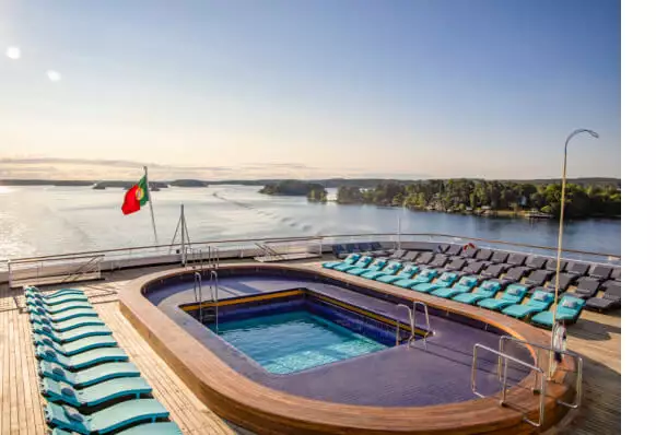 Pool mit blauen Sonnenliegen auf dem Deck eines Kreuzfahrtschiffes