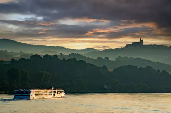 Kreuzfahrtschiff auf der Donau Kreuzfahrtschiff auf der Donau mit Berg- Kulisse