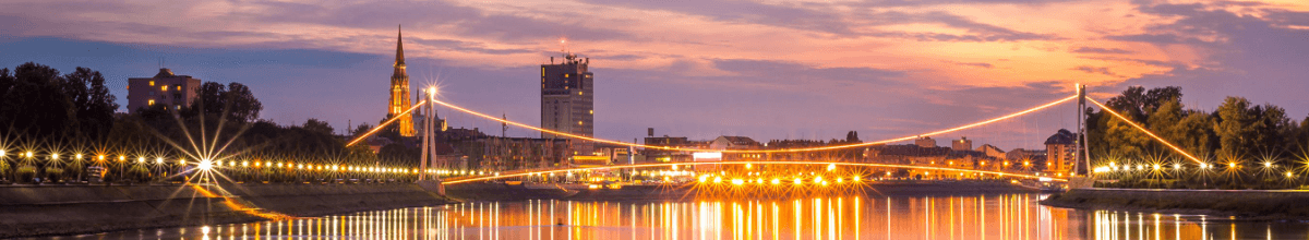 Über Osijek und dem Fluss Drau geht die Sonne unter.