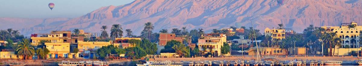 Luxor von der Flussseite aus mit Heißluftballon am Himmel.