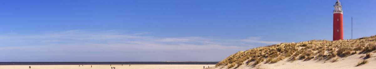 Roter Leuchtturm auf der Düne am weißen Strand in Texel.