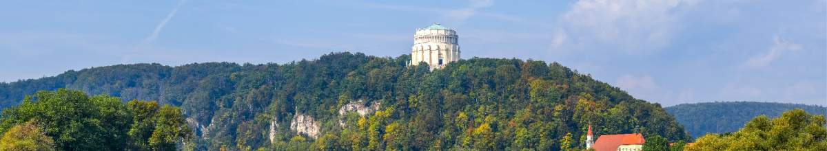 Zu sehen ist die Befreiungshalle, welche aus grünen Felsen heraussticht.