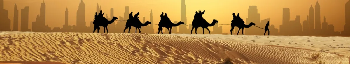 Eine goldene Wüste im Orient mit Kamelen vor der Skyline einer großen Stadt.