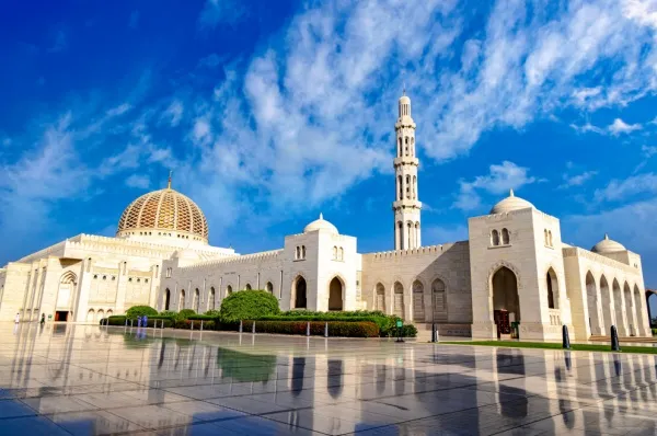 Große weiße Moschee mit poliertem Boden und blauem Himmel.