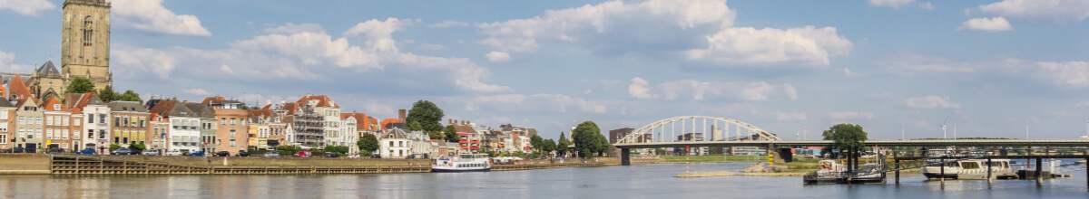 Deventer Skyline mit Kirchturm, Häusern und Booten auf dem Fluss