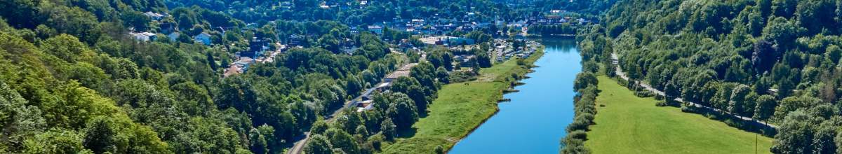 Die Weser fließt durch ein grünes Tal.