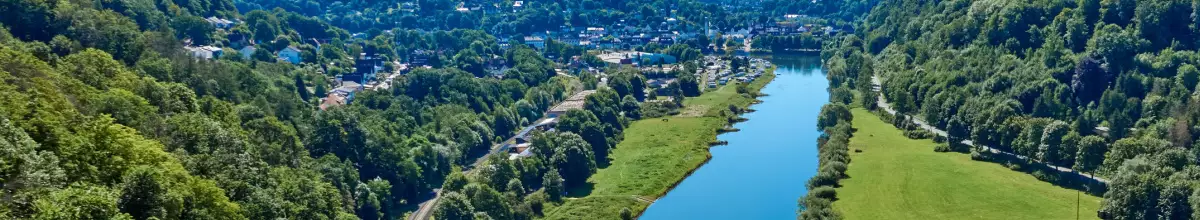 Die Weser fließt durch ein grünes Tal.
