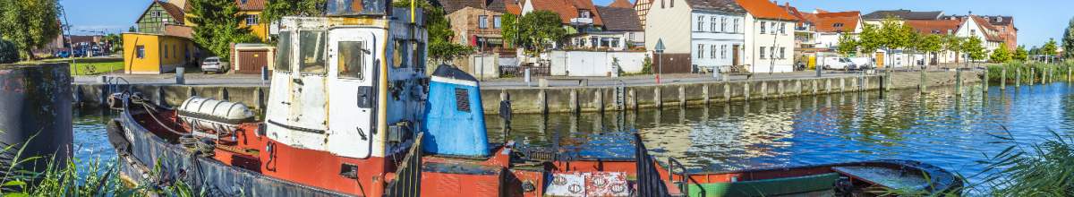 Ein altes Fischerboot legt am Hafen in Greifswald an.