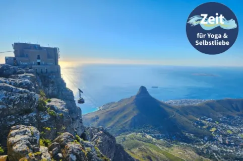 Seilbahn am Tafelberg mit dem Lions Head im Hintergrund. Rechts oben Logo der Themenreise Zeit für Yoga & Selbstliebe.